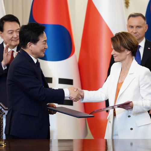 Wiceminister Jadwiga Emilewicz ściska dłoń z południowokoreańskim ministrem ziemi. 