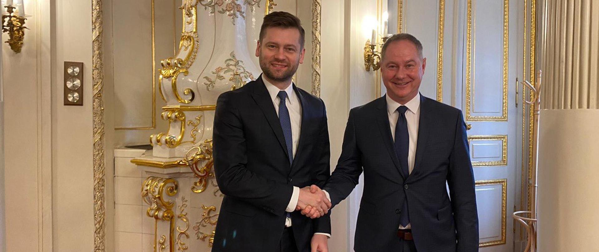 Na zdjęciu minister sportu i turystyki Kamil Bortniczuk i czeski minister do spraw sportu Peter Gazdik. Ministrowie ściskają sobie dłoń. Minister Kamil Bortniczuk przebywał z wizytą w Pradze
