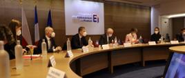 Minister rozwoju i technologii Piotr Nowak siedzi przy okrągłym stole, po jego obu stronach siedzą przedstawiciele firm francuskich skupionych w MEDEF