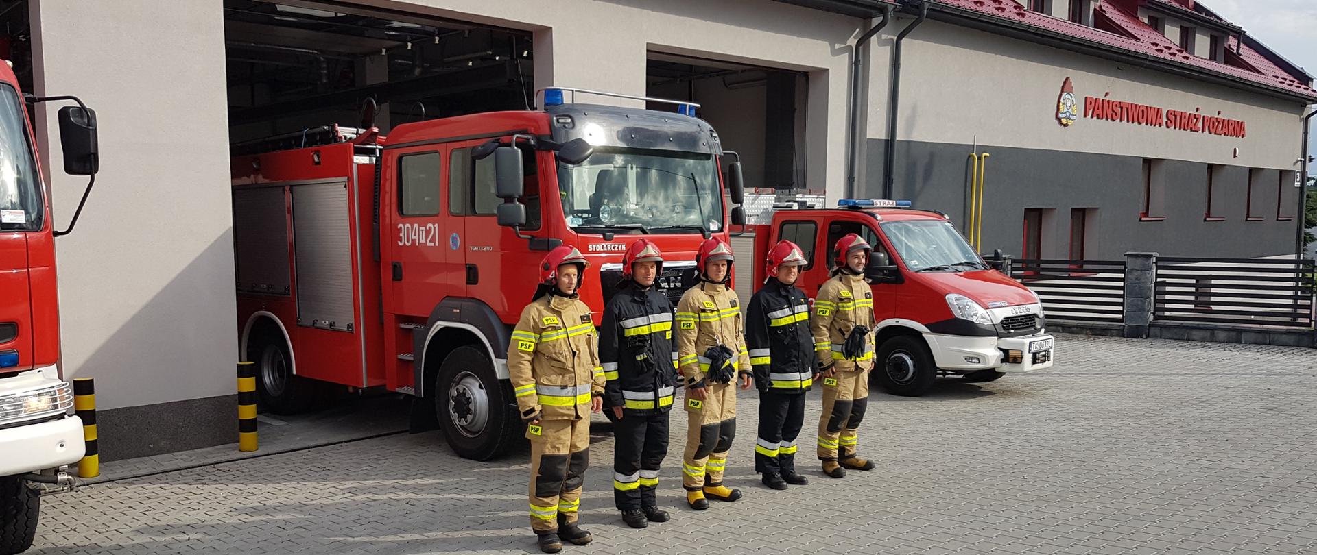 Na zdjęciu widać budynek Jednostki Ratowniczo-Gaśniczej nr 4 przed którym w jednym szyku stoją strażacy tej jednostki.