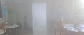 Na zdjęciu widzimy pomieszczenie stołówki zadymione sztucznym dymem, któ®y imituje warunki prawdziwego pożaru.