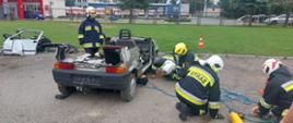egzamin praktyczny - uczestnicy szkolenia ewakuują poszkodowanego spod pojazdu za pomocą zestawu pneumatycznego