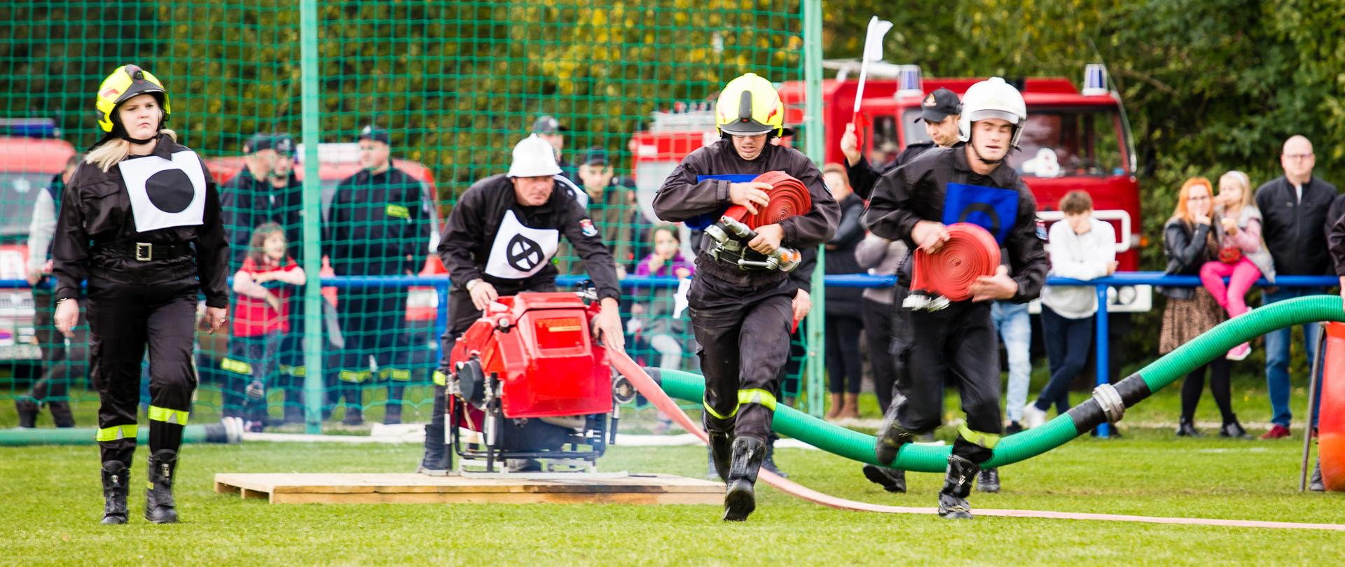 Zdjęcie przedstawia konkurencję bojówki w zawodach. Na zdjęciu kilka osób podczas wykonywania ćwiczenia.