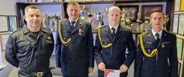 Komendant KP PSP w Chojnicach oraz strażacy z dyplomem na tle pucharów w sali tradycji.