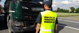 Umundurowany inspektor dolnośląskiej ITD, w odblaskowej kamizelce, stoi przed kontrolowaną wywrotką.