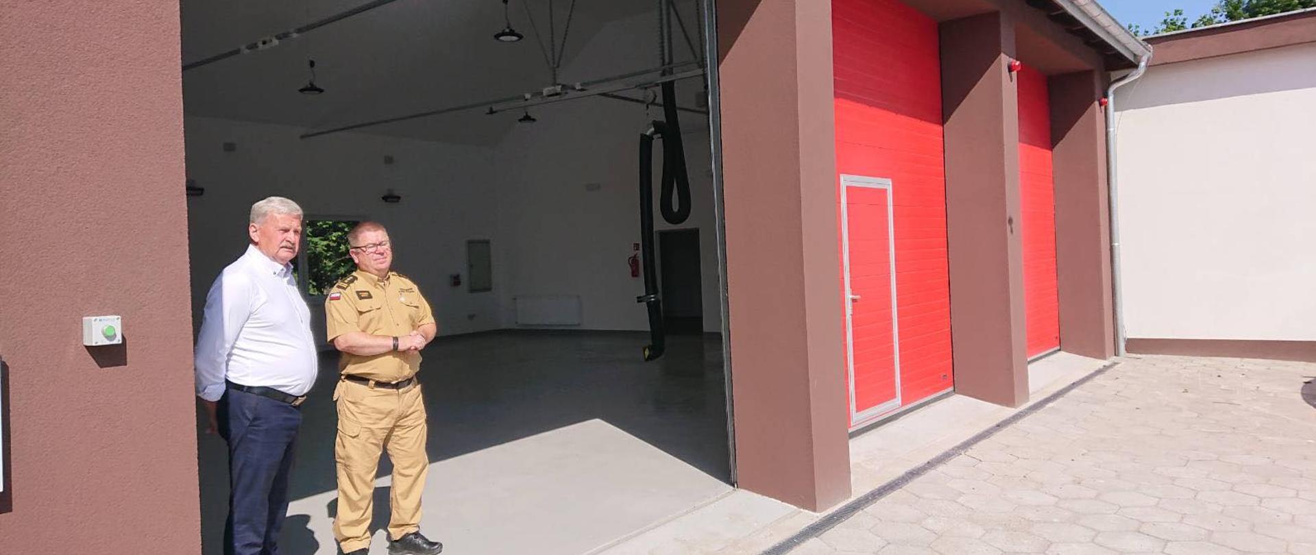 W nowo budowanej remizie OSP Stary Targ w otwartej bramie stoi Wójt Gminy Stary Targ oraz Zastępca Pomorskiego Komendanta Wojewódzkiego PSP w Gdańsku.