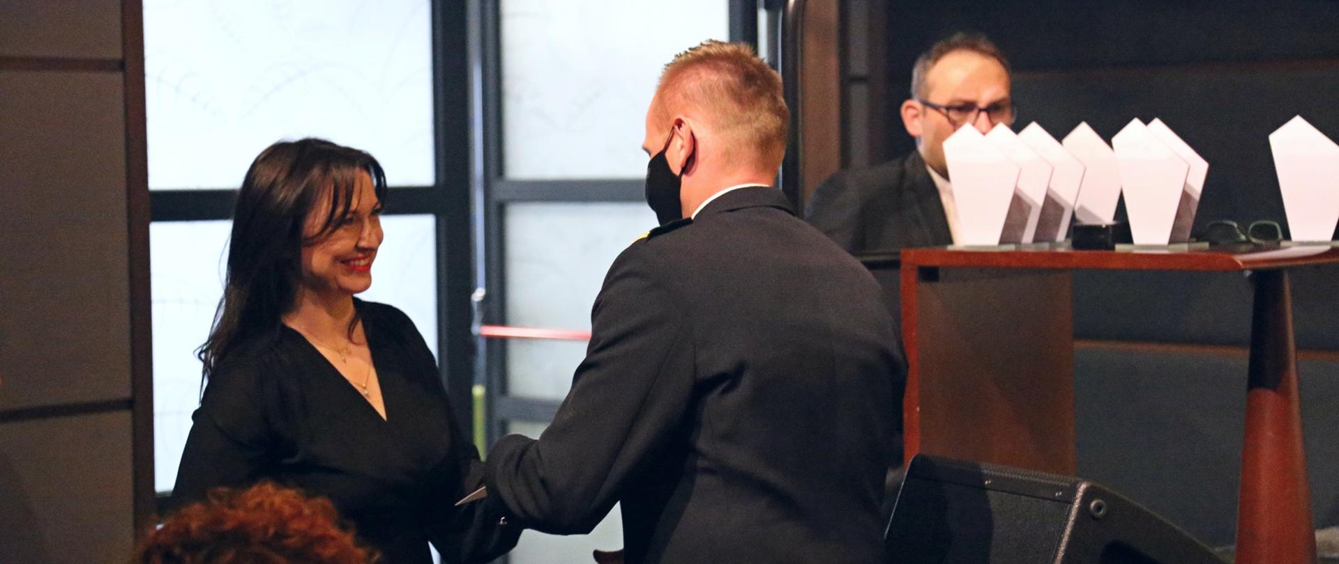 Zastępca Komendanta Centralnej Szkoły PSP odbiera podziękowania od przedstawicielki Towarzystwa Patriotycznego "Kresy"