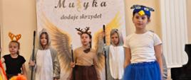 Wykonawcy na scenie w sali koncertowej podczas Koncertu końcoworocznego wpisującego się w szmaragdowy Jubileusz lublinieckiej szkoły muzycznej