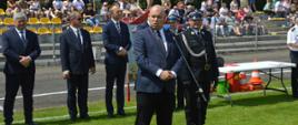 XI Powiatowe Zawody Sportowo-Pożarnicze OSP i MDP. Stadion w Miejskiej Górce. Na tle gości, komisji sędziowskiej i trybun, na których zasiadają kibice, do zebranych przemawia minister Jan Dziedziczak. 
