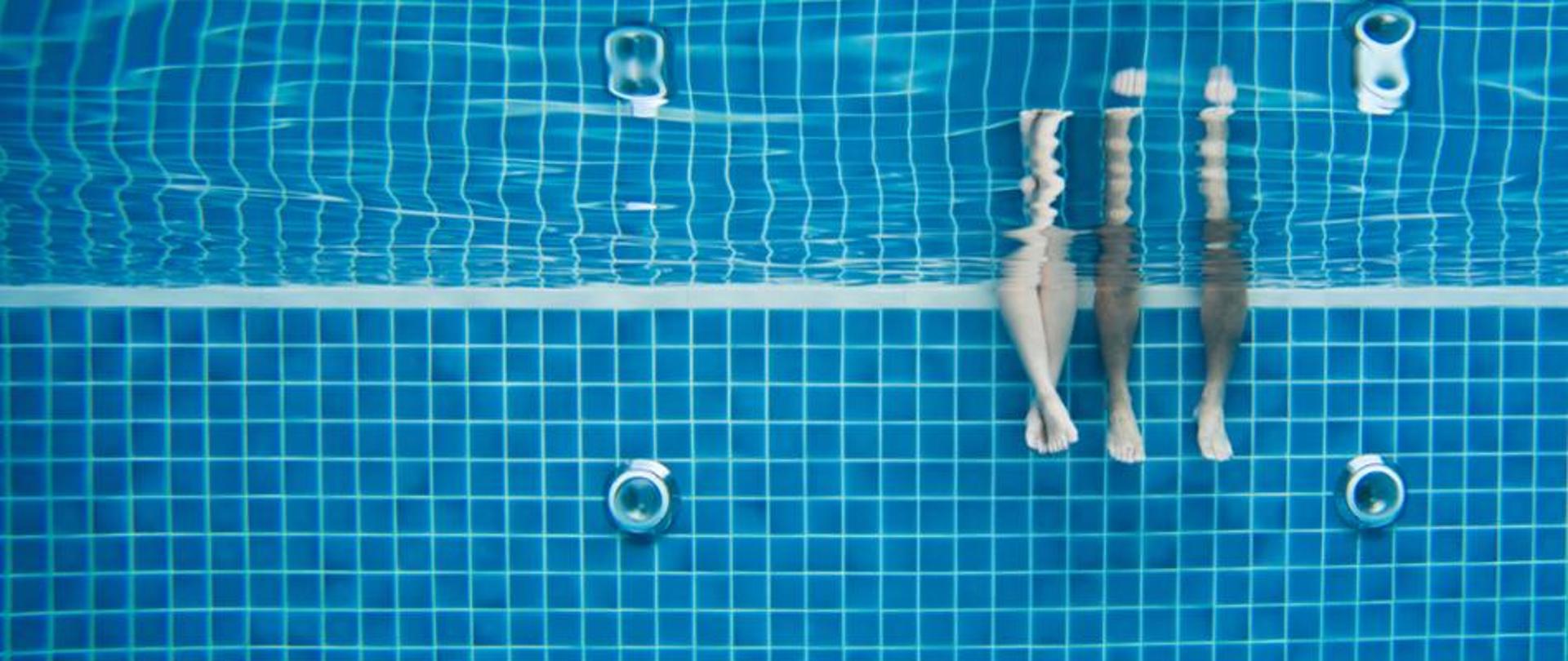 nogi zanurzone w wodzie basenowej