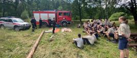 Zdjęcie przedstawia strażaków prowadzących szkolenie uczestników obozu harcerskiego