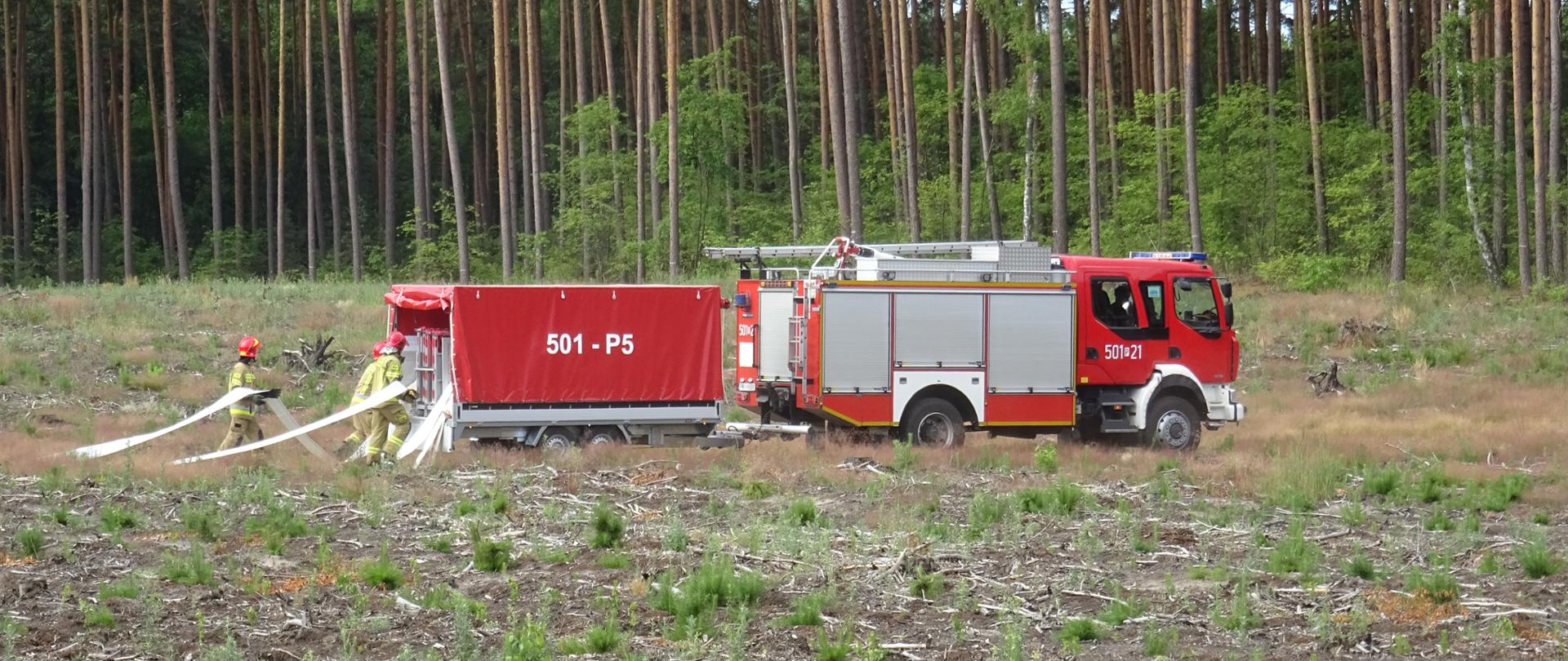 Na zdjęciu strażacy budują magistralę wodną.