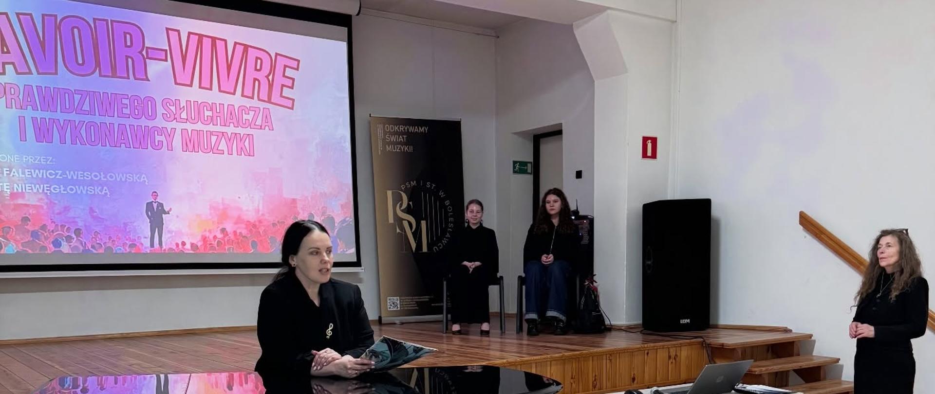 Zdjęcie przedstawiające prowadzących warsztaty savoir-vivre prawdziwego słuchacza i wykonawcy muzyki - panią Magdalenę Falewicz-Wesołowską oraz panią Małgorzatę Niewęgłowską. Warsztaty odbyły się 16 marca 2026 roku w auli szkoły.