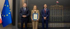 Kobieta i dwóch mężczyzn pozują do zdjęcia
