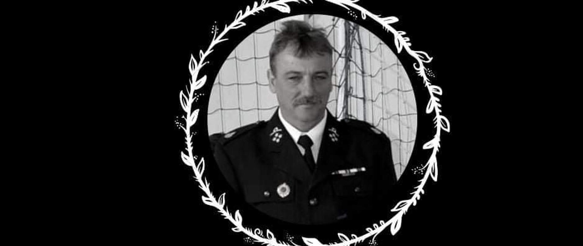 Plakat żałobny w kolorze czarnym, w kole umieszczone zdjęcie druha OSP poniżej tekst napisany biała czcionką na czarnym tle.