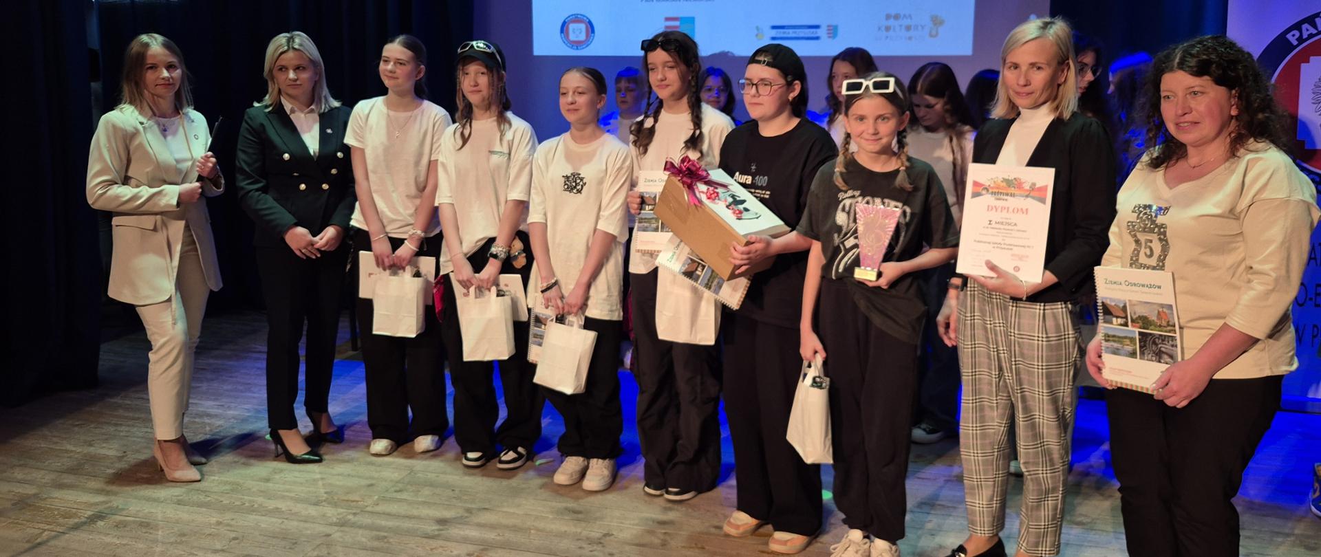 Zdjęcie przedstawia grupę dzieci wraz z pracownikami PSSE w Przysusze na 32 festiwalu piosenki o zdrowie