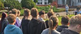 Funkcjonariusz PSP podczas omawiania przebiegu ewakuacji oraz pogadanki dla uczniów i kadry szkoły podstawowej.
