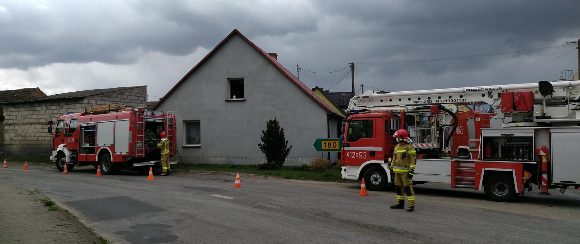 Strażacy wstrzymujący ruch na drodze 