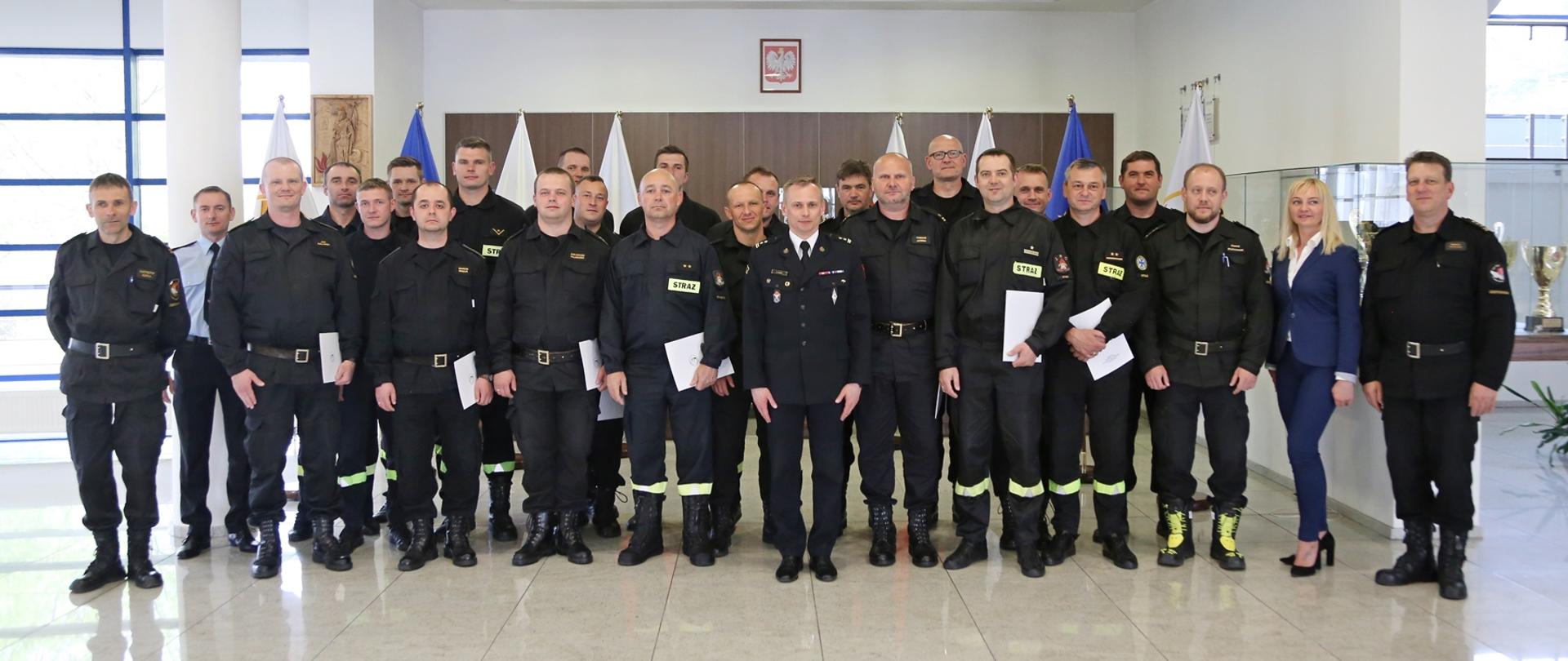 Grupowe zdjęcie uczestników szkolenia (20 osób) w towarzystwie Zastępcy Komendanta Centralnej Szkoły PSP oraz pracowników Szkoły (5 osób) sprawującymi nadzór nad szkoleniem