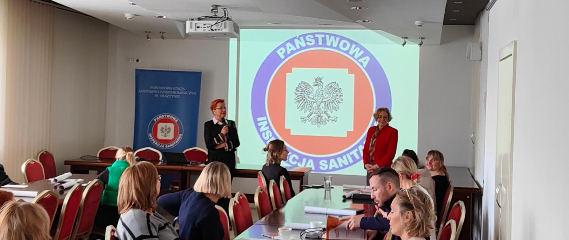 Szkolenie koordynatorów i realizatorów programu "Trzymaj formę!". Nauczycile siedzą przy ławach i słuchają prelegentów.