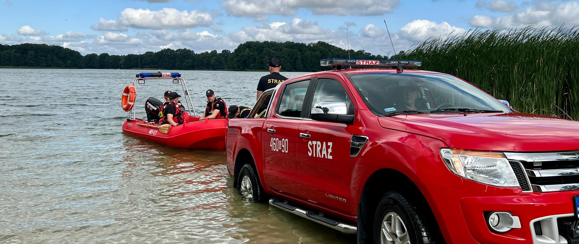 Strażacy wodują łódź ratowniczą.