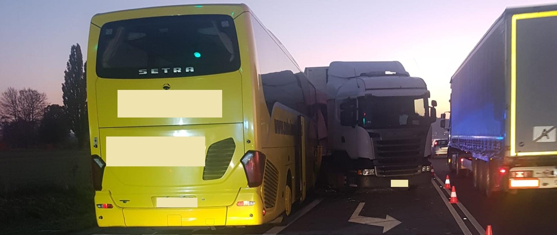 Widać tył autobus, po prawej samochód ciężarowy