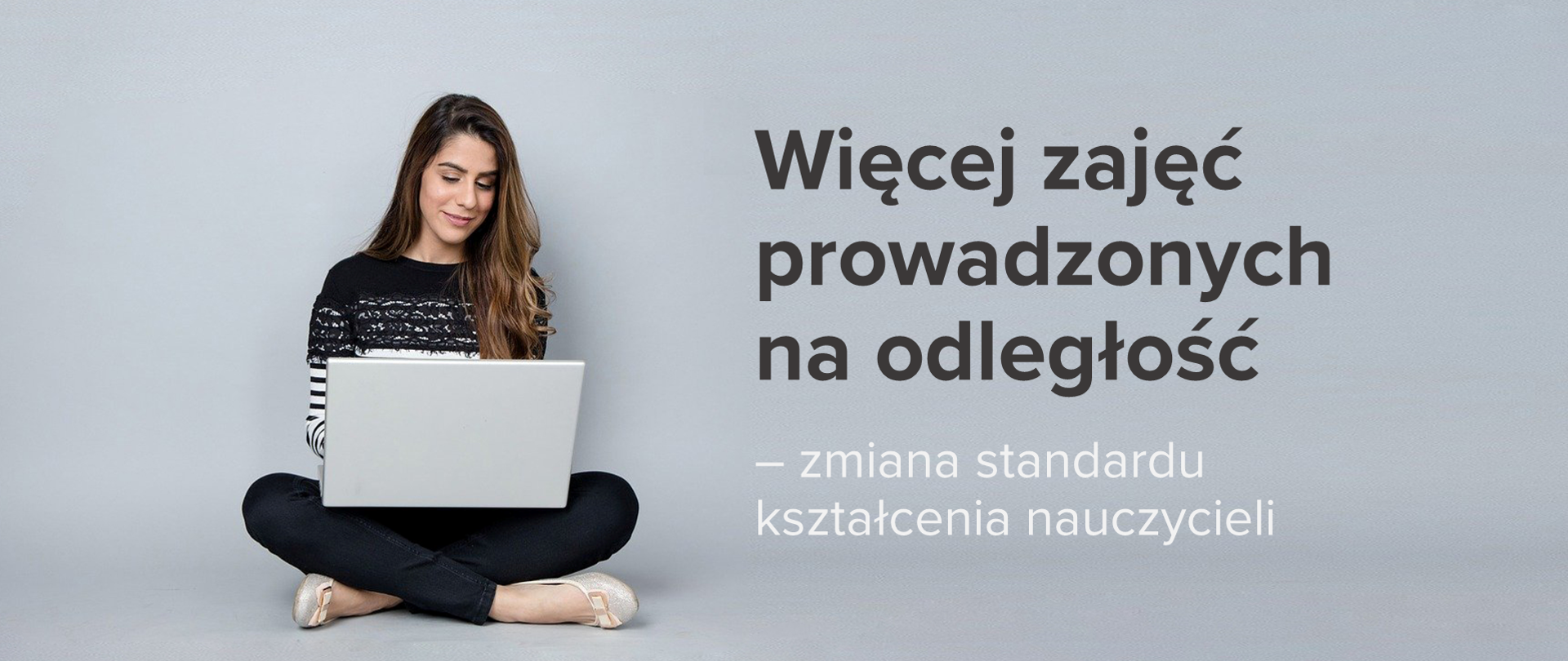 Szare tło. Po lewej stronie dziewczyna z długimi włosami siedzi na podłodze. Na kolanach trzyma laptopa. Po prawej stronie napis Więcej zajęć prowadzonych na odległość – zmiana standardu kształcenia nauczycieli