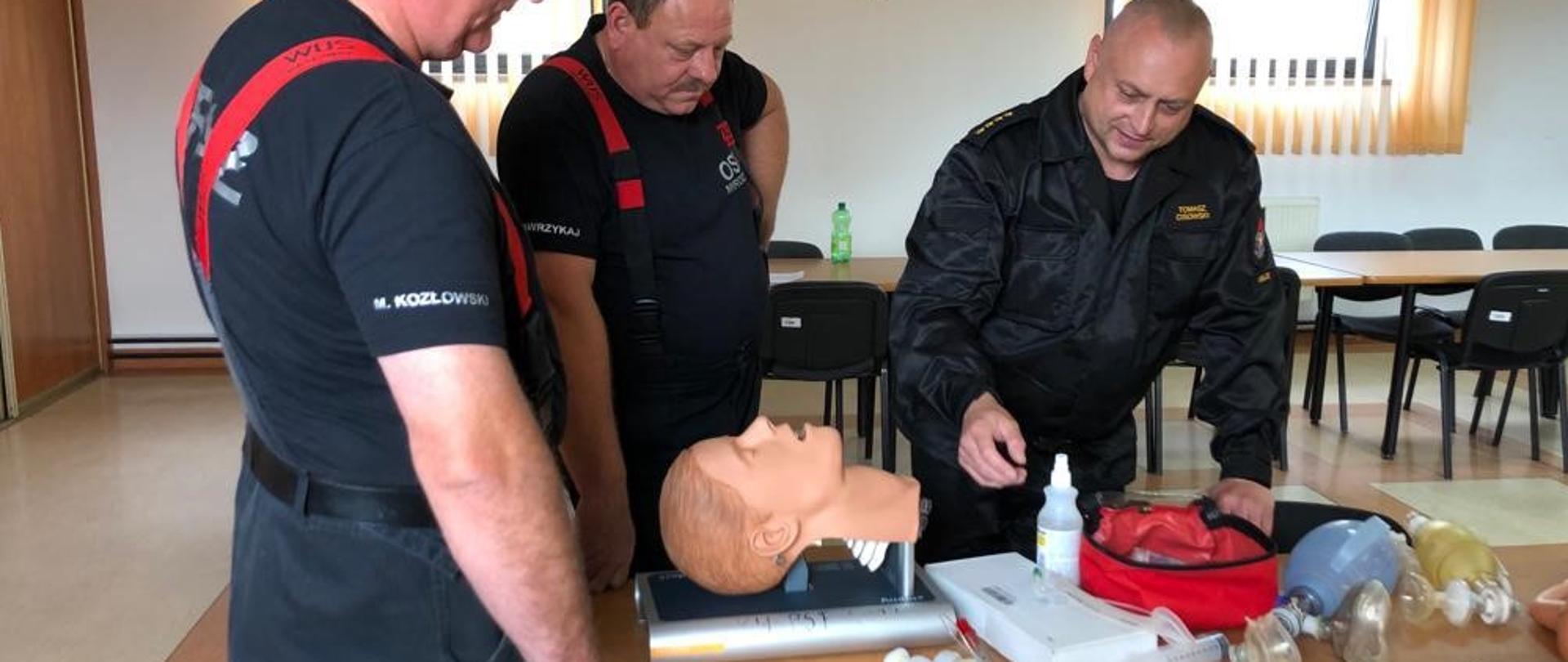 Na zdjęciu przedstawiono dwóch druhów, którzy zdają egzamin praktyczny. Egzaminującym jest st. kpt. Tomasz Cisowski.