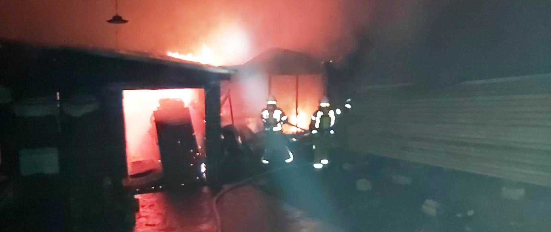 Ogień wewnątrz budynku a obok strażacy