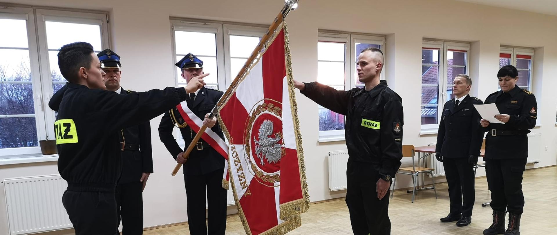 Ślubowanie strażaków w KP PSP Namysłów. Ślubujący oraz poczet sztandarowy podczas ślubowania.