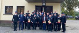 wspólne zdjęcie druhów osp i zaproszonych gości przed strażnicą osp
