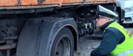 Kontrola stanu technicznego ciężarówki. Inspektorzy wielkopolskiej Inspekcji Transportu Drogowego stwierdzili liczne usterki w pojeździe przewożącym deski.