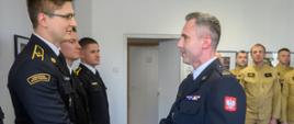 Na zdjeciu widoczny jest Komendant Powiatowy PSP w Ostrowcu Świętokrzsykim Marcin Jasiński wręczający mianowanie na wyższe stanowisko funkcjonariuszowi