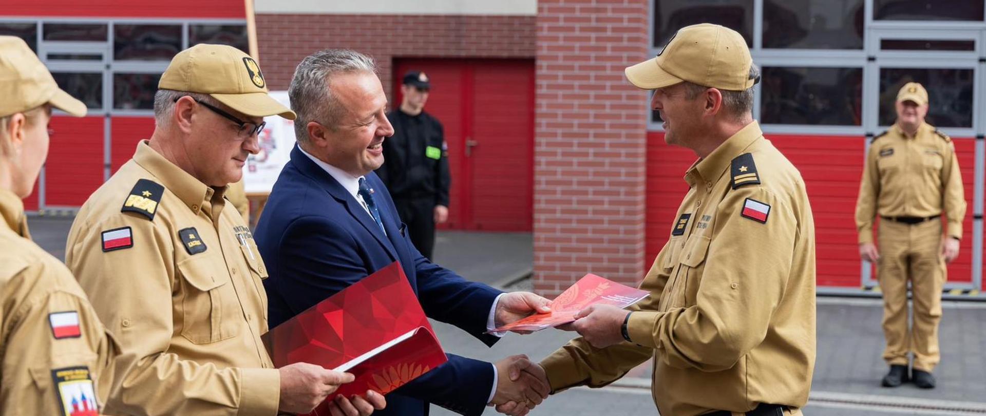 Na zdjęciu widać moment przekazana dokumentów przez Wojewodę Kujawsko- Pomorskiego na ręce Komendanta Powiatowego PSP w Chełmnie.