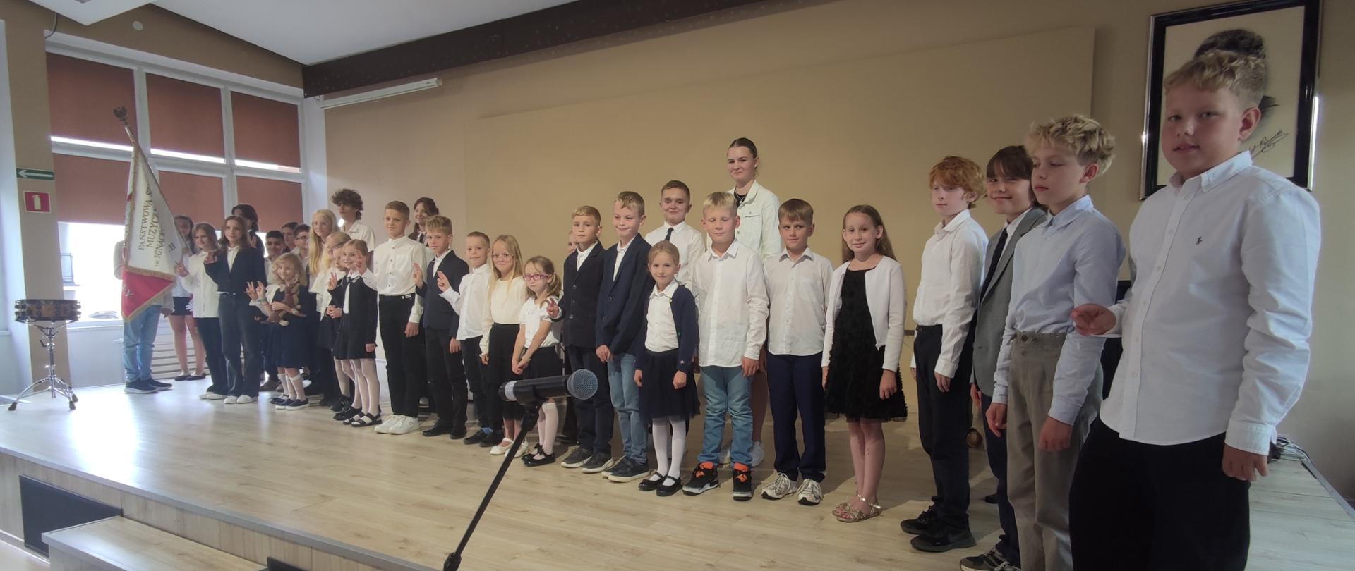 uczniowie stojący na scenie