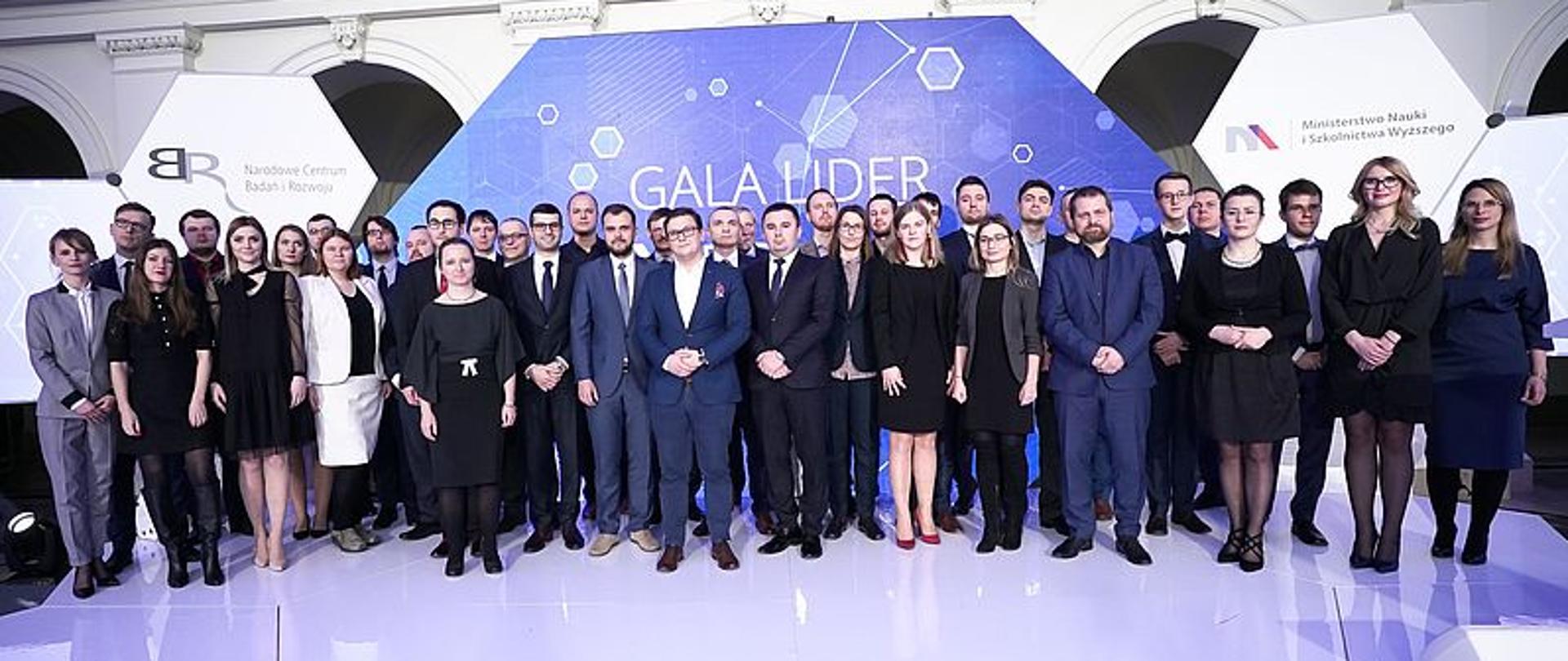 Grupa ludzi stojąca na scenie konkursu