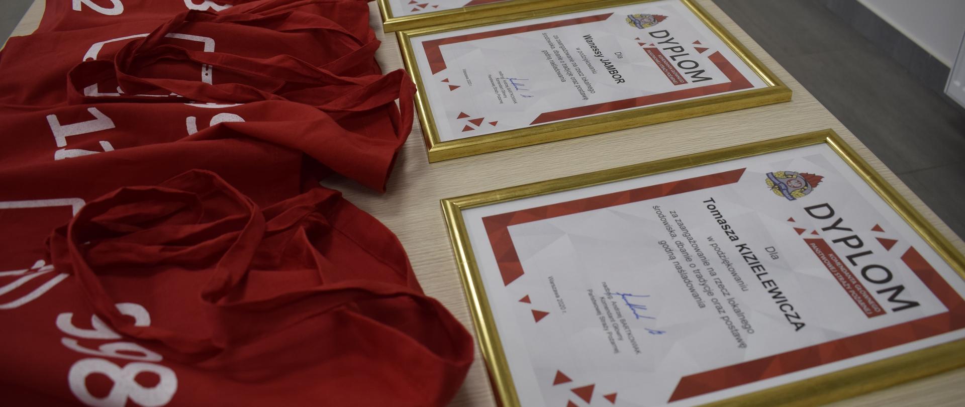 Na stole ułożone są dyplomy oraz upominki dla członków MDP Kwilcz