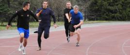 Zawodnicy w biegu sztafetowym podczas zmiany na łuku bieżni