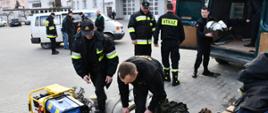 Na zdjęciu widzimy strażaków wyładowujących i segregujących sprzęt strażacki przywieziony przez druhów OSP. 