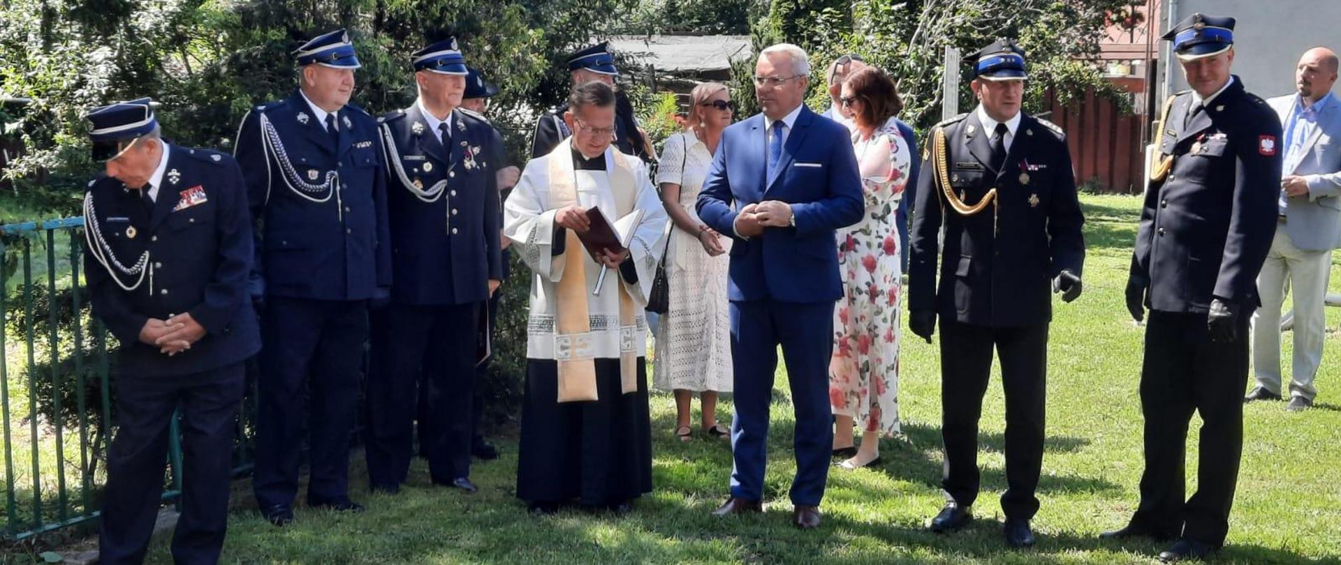 Przedstawiciele władz kościoła i państwa wraz z przedstawicielami władz Państwowej i Ochotniczych Straży Pożarnych uczestniczą w zbiórce przed remizą OSP w Gulbinach. 