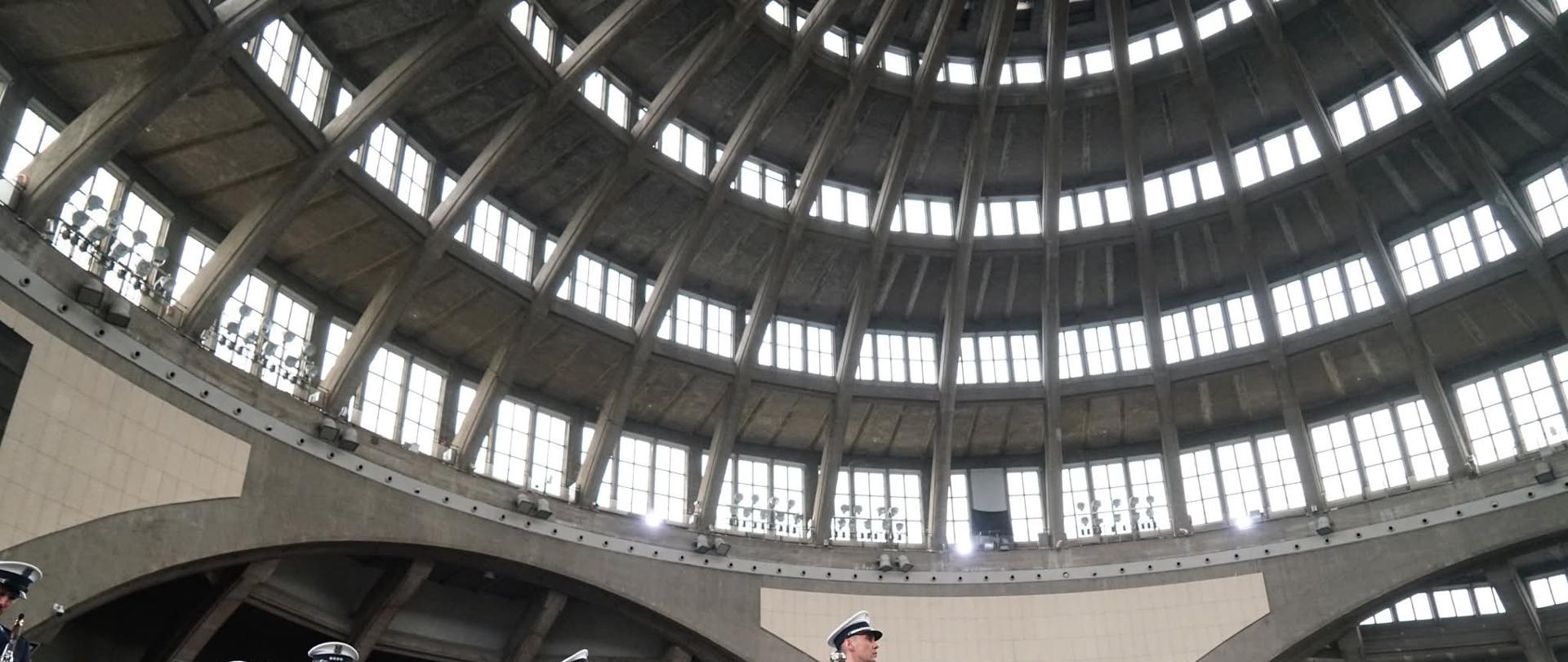 Na pierwszym planie orkiestra policyjna, na drugim planie szpaler policjantów na płycie głównej Hali Stulecia podczas uroczystości Święta Policji. 