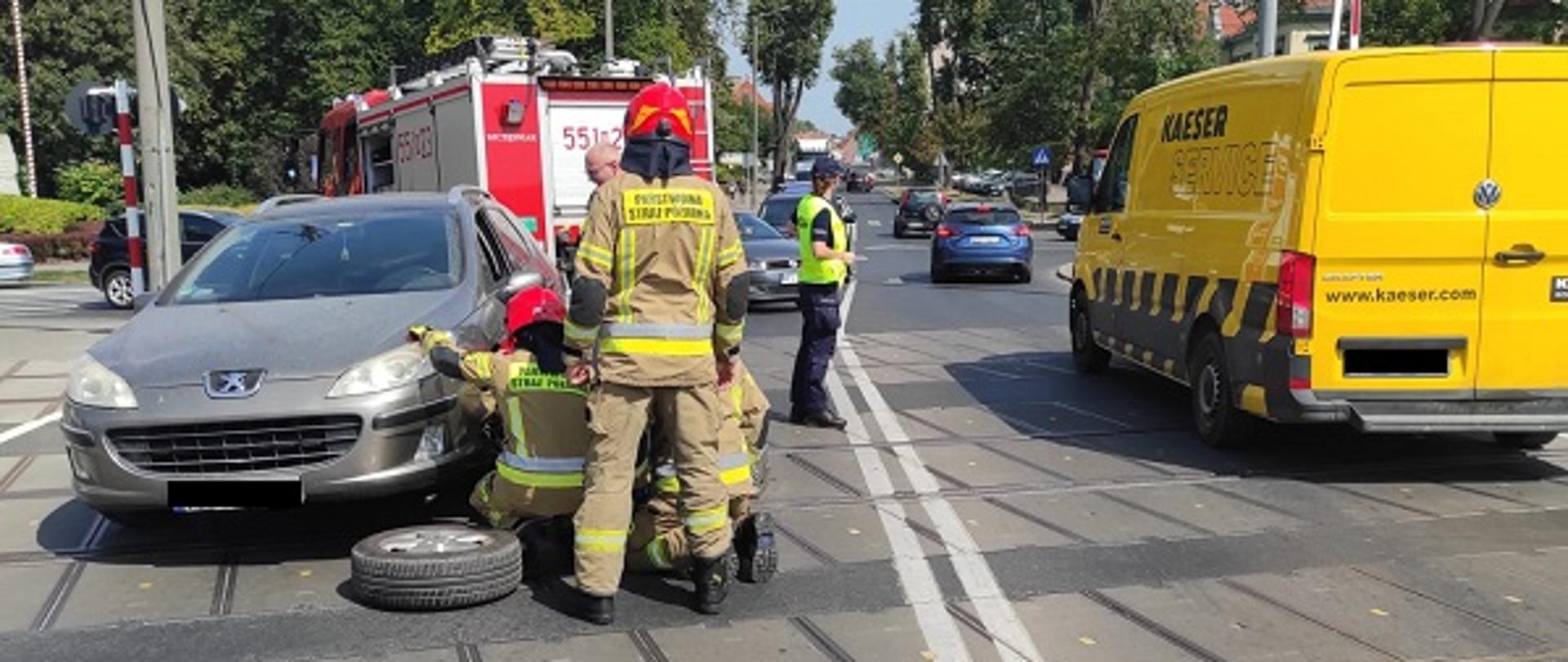 Zdjęcie przedstawia strażaków usuwających usterkę w pojeździe