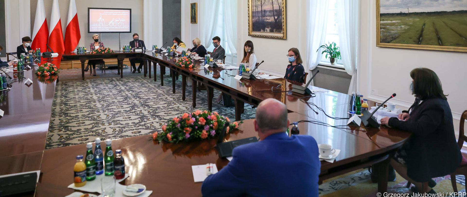 uczestnicy konferencji siedzą wokół stołu, widoczna Pierwsza Dama Agata Kornhauser-Duda
