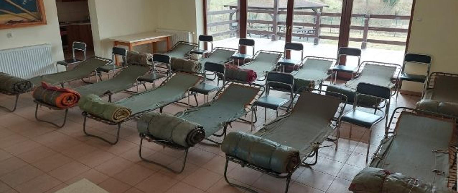 Zdjęcie przedstawia miejsca noclegowe dla uchodźców wewnątrz pomieszczeń. 