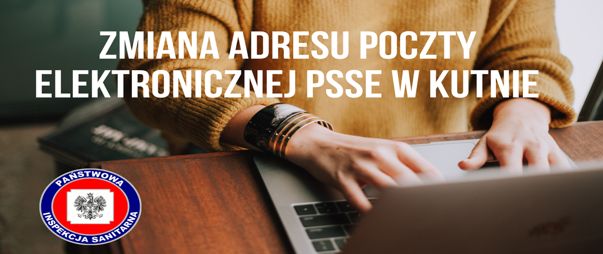 Zmiana adresu poczty elektronicznej PSSE w Kutnie w tle siedzi ko bieta i pisze na laptopie, poniżej znajduje się symbol Państwowej Inspekcji Sanitarnej.