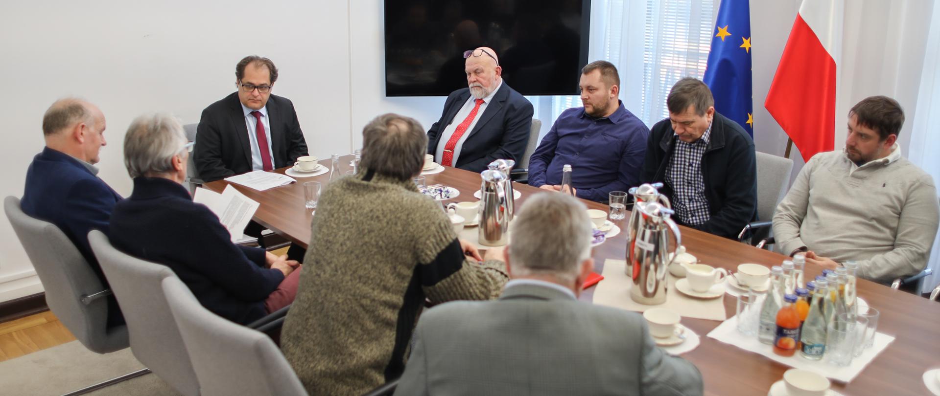 Spotkanie ministra Marka Gróbarczyka z przedstawicielami rybołówstwa rekreacyjnego. Uczestnicy spotkania rozmawiają przy stole.
