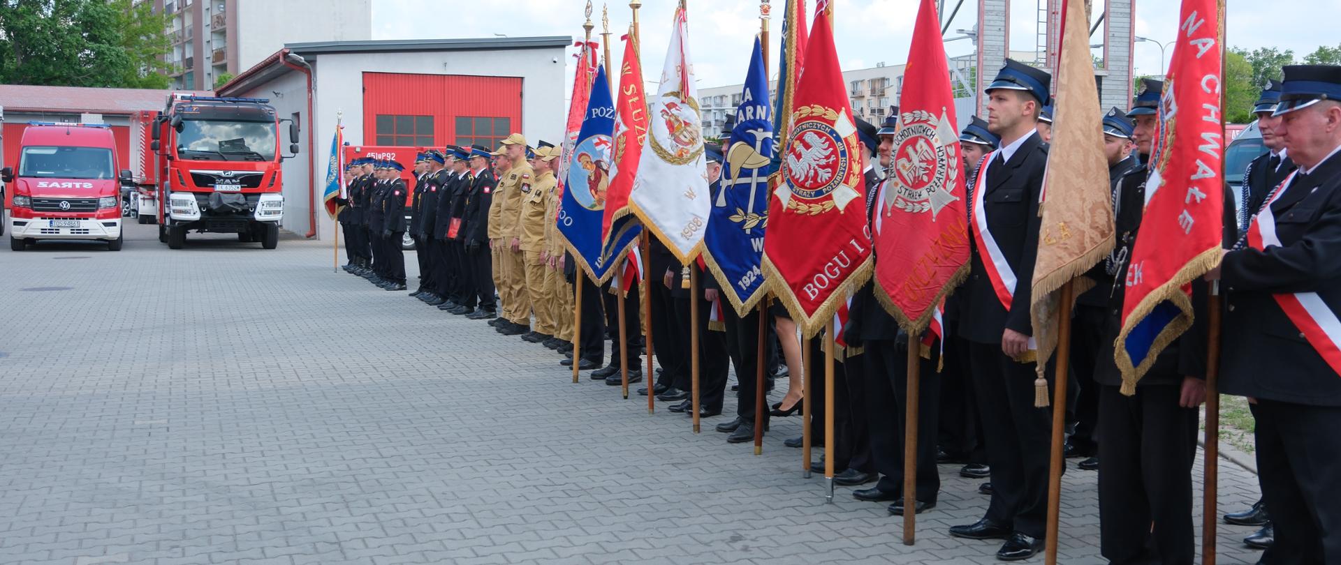 Na zdjęciu widoczne są pododdziały Państwowej Straży Pożarnej i Ochotniczej straży Pożarnej z terenyu powiatu ostrowieckiego oraz poczty sztandarowe stojący w szyku podczas uroczystośći.
