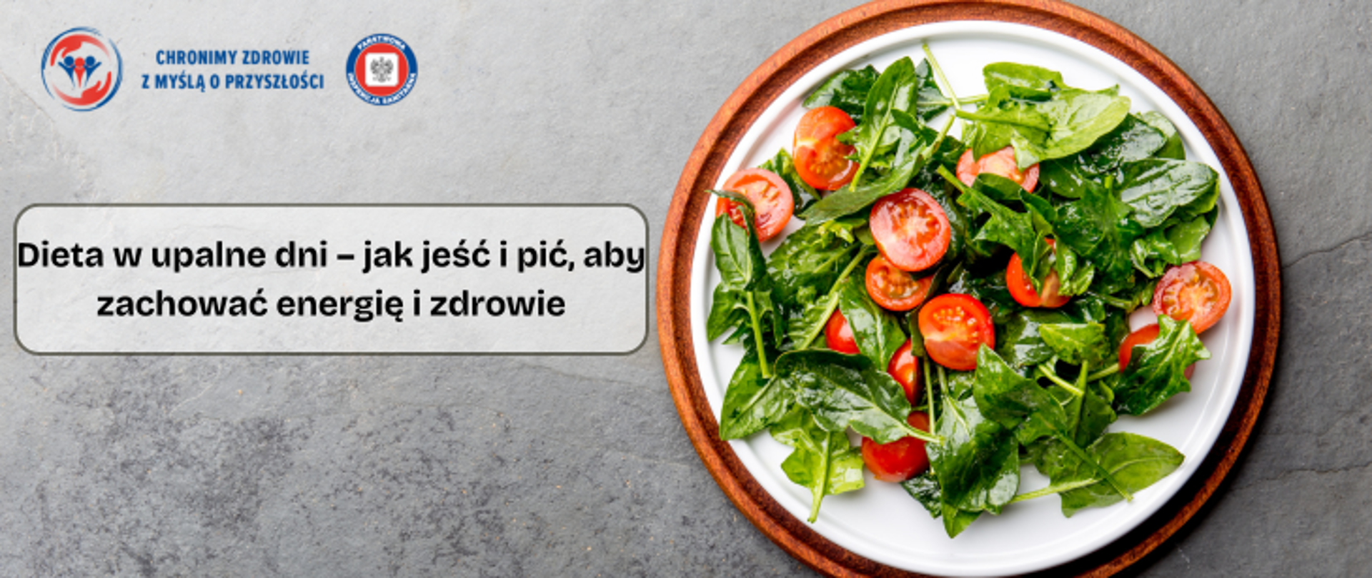 Na szarym tle po prawej biały talerz z letnią sałatką składająca się z zielonych warzyw liściastych i pomidorów. Po lewej stronie napis Dieta w upalne dni- jak jeść i pić, aby zachować energię i zdrowie. w lewym górnym logo inspekcji sanitarnej wraz z napisem chronimy zdrowie z myślą o przyszłości.