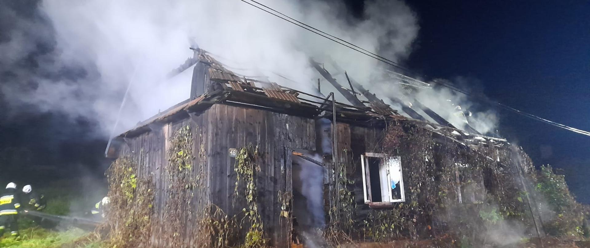 Płonący drewniany budynek 