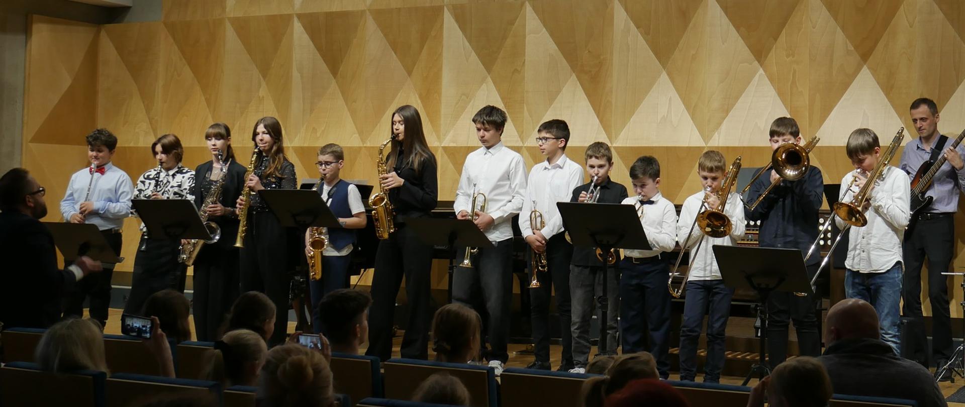 Zespół instrumentów dętych na scenie sali koncertowej